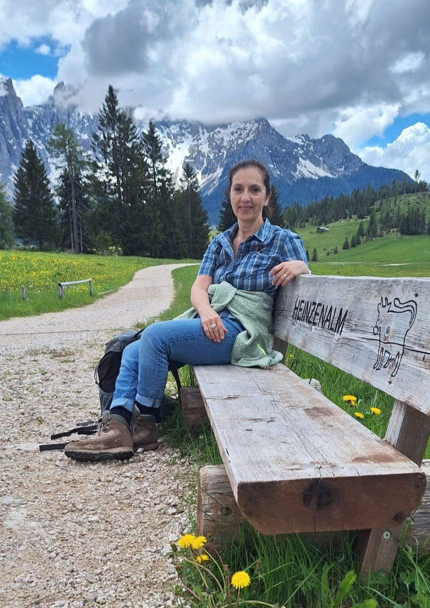 Ein Foto von mir auf einer Sitzbank in den Alpen. 